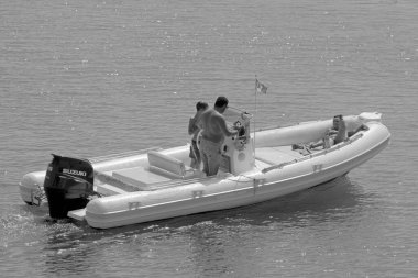 İtalya, Sicilya, Akdeniz, Marina di Ragusa (Ragusa Eyaleti); 18 Eylül 2021, limandaki kauçuk bir teknede insanlar - EDITORIAL