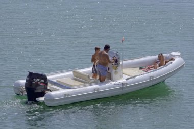 İtalya, Sicilya, Akdeniz, Marina di Ragusa (Ragusa Eyaleti); 18 Eylül 2021, limandaki kauçuk bir teknede insanlar - EDITORIAL