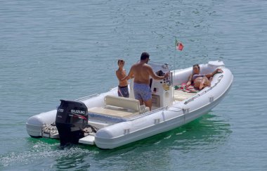 İtalya, Sicilya, Akdeniz, Marina di Ragusa (Ragusa Eyaleti); 18 Eylül 2021, limandaki kauçuk bir teknede insanlar - EDITORIAL