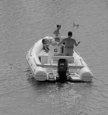 İtalya, Sicilya, Akdeniz, Marina di Ragusa (Ragusa Eyaleti); 18 Eylül 2021, limandaki kauçuk bir teknede insanlar - EDITORIAL