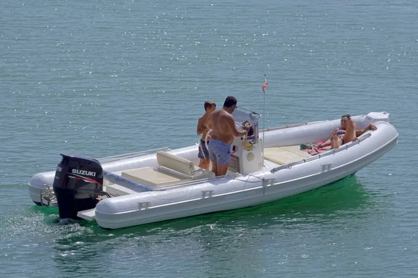 İtalya, Sicilya, Akdeniz, Marina di Ragusa (Ragusa Eyaleti); 18 Eylül 2021, limandaki kauçuk bir teknede insanlar - EDITORIAL