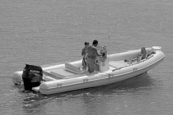 İtalya, Sicilya, Akdeniz, Marina di Ragusa (Ragusa Eyaleti); 18 Eylül 2021, limandaki kauçuk bir teknede insanlar - EDITORIAL