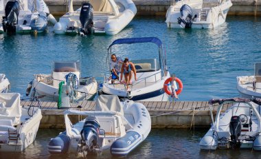 İtalya, Sicilya, Akdeniz, Marina di Ragusa (Ragusa ili); 19 Eylül 2021, limandaki bir motorlu tekne ve lüks yatlarda yaşayan insanlar - EDITORIAL