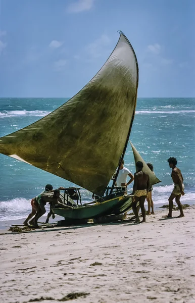 People hauling boat on beach — Stock Photo, Image