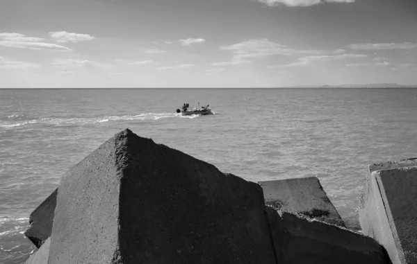 Barca da pesca in legno e blocchi di cemento fuori dal porto — Foto Stock