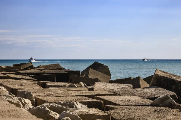 Рыбацкие лодки и бетонные блоки за пределами порта — стоковое фото