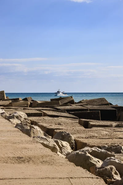 Barca da pesca e blocchi di cemento fuori dal porto — Foto Stock