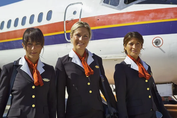 Vlucht assistenten in de buurt van een vliegtuig — Stockfoto