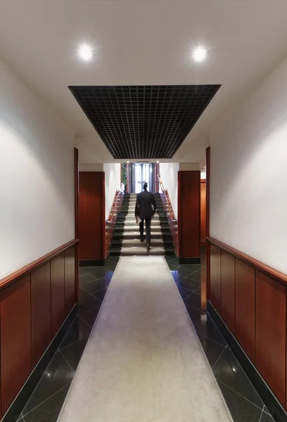 Businessman walking in a corporate building corridor — Stock Photo, Image