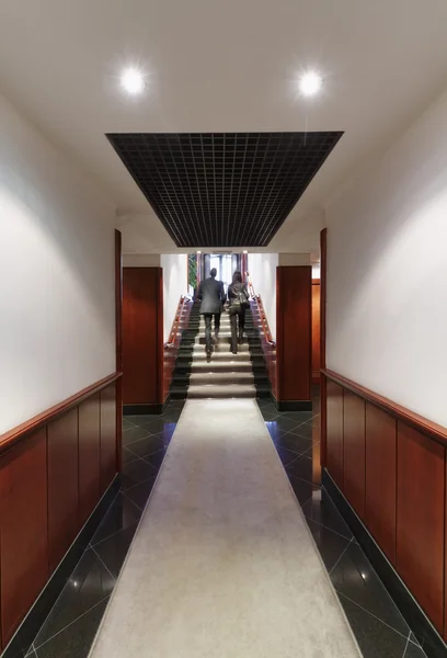 商界人士在公司楼的走廊上散步 — 图库照片