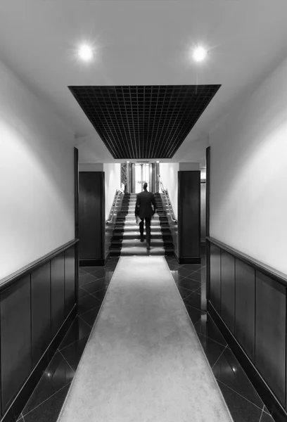 Бизнесмен, идущий по корпоративному строительному коридору — стоковое фото