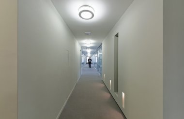 Bir kurumsal yapı koridorda yürüyen adam