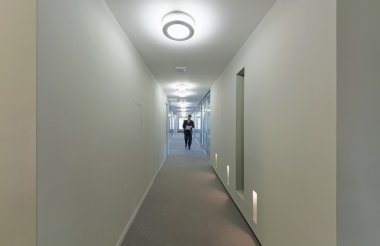 Bir kurumsal yapı koridorda yürüyen adam