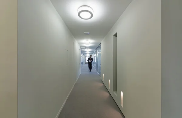 Homem caminhando em um corredor de edifício corporativo — Fotografia de Stock