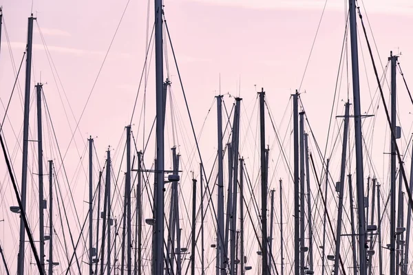 Plachetnicových stěžňů v přístavu při západu slunce — Stock fotografie