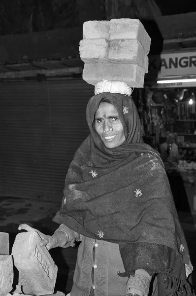 Indisk kvinna som bär tegel på hennes huvud — Stockfoto
