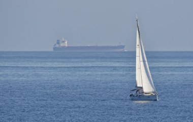 yelkenli tekne ve bir kargo gemisi İtalya