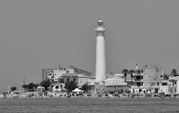 Lighthouse and people on the beach Stock Image