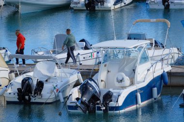 İtalya, Sicilya, Akdeniz, Marina di Ragusa (Ragusa ili); 7 Ekim 2025, limanda insanlar, motorlu tekneler ve lüks yatlar - EDITORIAL