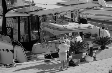 İtalya, Sicilya, Akdeniz, Marina di Ragusa (Ragusa Eyaleti); 7 Ekim 2025, limanda insanlar ve bir katamaran yelkenli teknesi - EDITORIAL