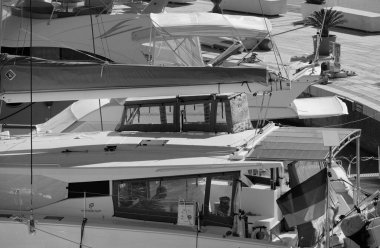 İtalya, Sicilya, Akdeniz, Marina di Ragusa (Ragusa Eyaleti); 8 Ekim 2025, limandaki bir katamaran yelkenli teknesinde adam - EDITORIAL