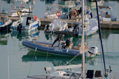 İtalya, Sicilya, Akdeniz, Marina di Ragusa (Ragusa Eyaleti); 11 Ekim 2025, limanda büyük bir kauçuk teknede adam - EDITORIAL