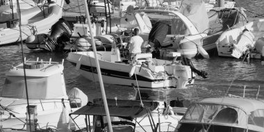 İtalya, Sicilya, Akdeniz, Marina di Ragusa (Ragusa Eyaleti); 13 Ekim 2025, limanda bir motorlu tekne ve lüks yatlarda adam - EDITORIAL