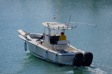 İtalya, Sicilya, Akdeniz, Marina di Ragusa (Ragusa Eyaleti); 21 Ekim 2025, limandaki bir motorlu teknede balıkçı - EDITORIAL