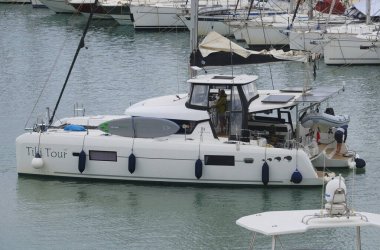 İtalya, Sicilya, Akdeniz, Marina di Ragusa (Ragusa Eyaleti); 30 Ekim 2025, limandaki katamaran yelkenli teknesinde insanlar - EDITORIAL