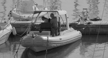 İtalya, Sicilya, Akdeniz, Marina di Ragusa (Ragusa ili); 13 Aralık 2025, limanda bir kauçuk teknede çift - EDITORIAL