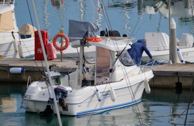 İtalya, Sicilya, Akdeniz, Marina di Ragusa (Ragusa Eyaleti); 13 Aralık 2025, limandaki bir motorlu teknede balıkçı - EDITORIAL