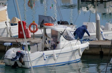 İtalya, Sicilya, Akdeniz, Marina di Ragusa (Ragusa Eyaleti); 13 Aralık 2025, limandaki bir motorlu teknede balıkçı - EDITORIAL