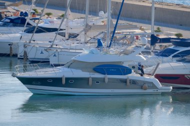 İtalya, Sicilya, Akdeniz, Marina di Ragusa (Ragusa Eyaleti); 14 Aralık 2025, limanda lüks bir yatta çift - EDITORIAL