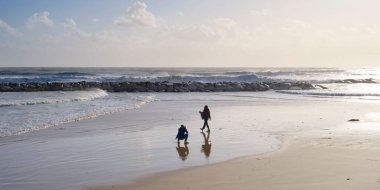 İtalya, Sicilya, Akdeniz, Marina di Ragusa (Ragusa Eyaleti), sahilde bir kadının fotoğraflarını çeken fotoğrafçı.