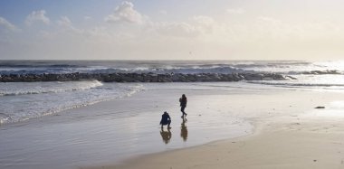 İtalya, Sicilya, Akdeniz, Marina di Ragusa (Ragusa Eyaleti), sahilde bir kadının fotoğraflarını çeken fotoğrafçı.
