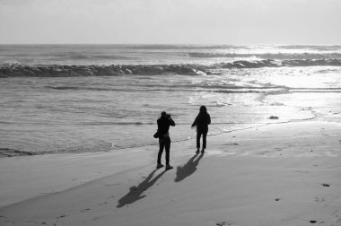 İtalya, Sicilya, Akdeniz, Marina di Ragusa (Ragusa Eyaleti), sahilde bir kadının fotoğraflarını çeken fotoğrafçı.