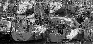 İtalya, Sicilya, Akdeniz, Marina di Ragusa (Ragusa ili); 18 Aralık 2024, limandaki insanlar ve yelkenliler - EDITORIAL