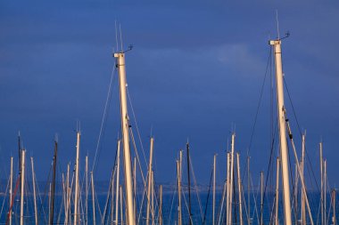 İtalya, Sicilya; Marina di Ragusa (Ragusa Eyaleti); gün batımında limanda yelkenli gemi direkleri