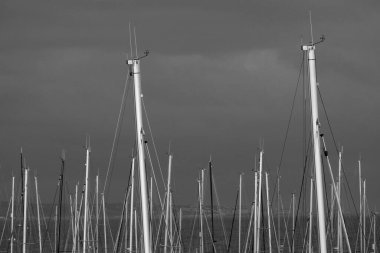 İtalya, Sicilya; Marina di Ragusa (Ragusa Eyaleti); gün batımında limanda yelkenli gemi direkleri