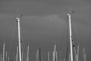 İtalya, Sicilya; Marina di Ragusa (Ragusa Eyaleti); gün batımında limanda yelkenli gemi direkleri