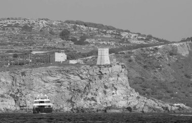 Malta Adası, adanın güney kıyısı, eski bir Türk kulesi ve lüks bir yat manzarası.