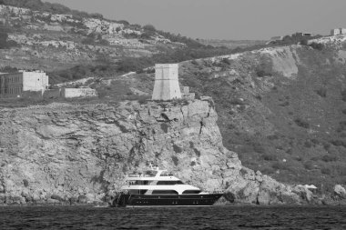 Malta Adası, adanın güney kıyısı, eski bir Türk kulesi ve lüks bir yat manzarası.