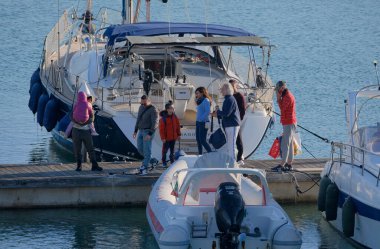 İtalya, Sicilya, Akdeniz, Marina di Ragusa (Ragusa ili); 28 Aralık 2025, limandaki insanlar, motorlu tekneler ve lüks yatlar - EDITORIAL