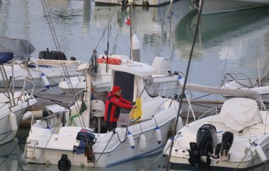 İtalya, Sicilya, Akdeniz, Marina di Ragusa (Ragusa Eyaleti); 29 Aralık 2025, limandaki bir motorlu teknede adam - EDITORIAL