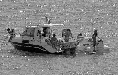 İtalya, Sicilya, Akdeniz, Marina di Ragusa (Ragusa Eyaleti); 12 Eylül 2015, denizde motorlu teknelerde insanlar - EDITORIAL