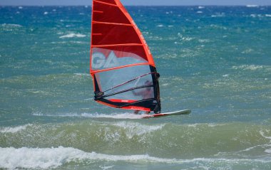 İtalya, Sicilya, Akdeniz, Donnalucata (Ragusa Eyaleti); 20 Ağustos 2024, dalgalara binen sörfçü - EDITORIAL