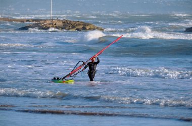 İtalya, Sicilya, Akdeniz, Marina di Ragusa (Ragusa ili); 7 Aralık 2021, denizde sörfçü - EDITORIAL