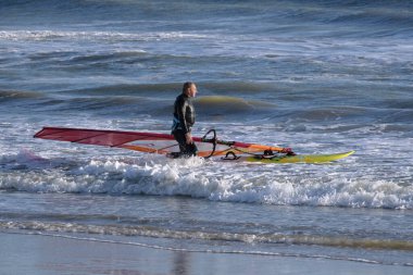 İtalya, Sicilya, Akdeniz, Marina di Ragusa (Ragusa ili); 7 Aralık 2021, denizde sörfçü - EDITORIAL