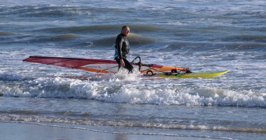 İtalya, Sicilya, Akdeniz, Marina di Ragusa (Ragusa ili); 7 Aralık 2021, denizde sörfçü - EDITORIAL