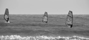 İtalya, Sicilya, Akdeniz, Marina di Ragusa (Ragusa ili); 7 Aralık 2021, denizde sörfçüler - EDITORIAL